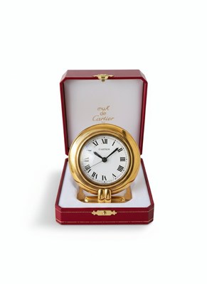 Lot 26 - CARTIER - "MUST DE CARTIER" TRAVEL CLOCK
A fine and elegant gilt-metal and lacquer quartz travel clock by Cartier, Paris.