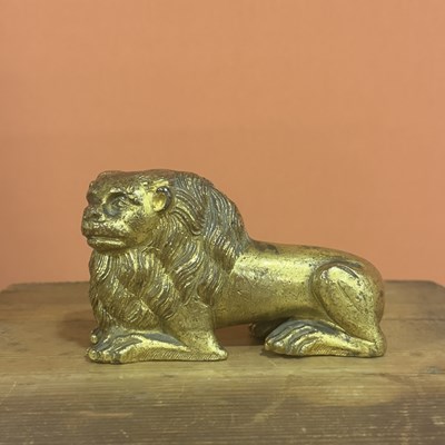 Lot 28 - A hollow-cast chased and gilt bronze figure of a recumbent lion