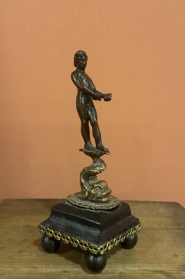 Lot 34 - A patinated and gilt-bronze figure of a nude young man standing on a dolphin