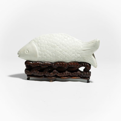 Lot 112 - A white glazed chinese porcelain figure of a carp "Koi fish"on a wooden display stand